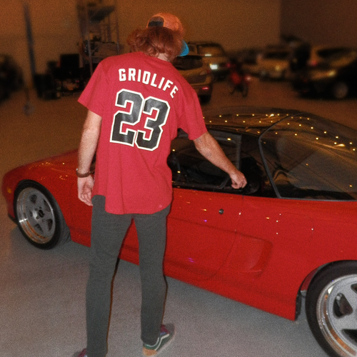 Person wearing GRIDLIFE 23 Legends jersey opeing door of NSX