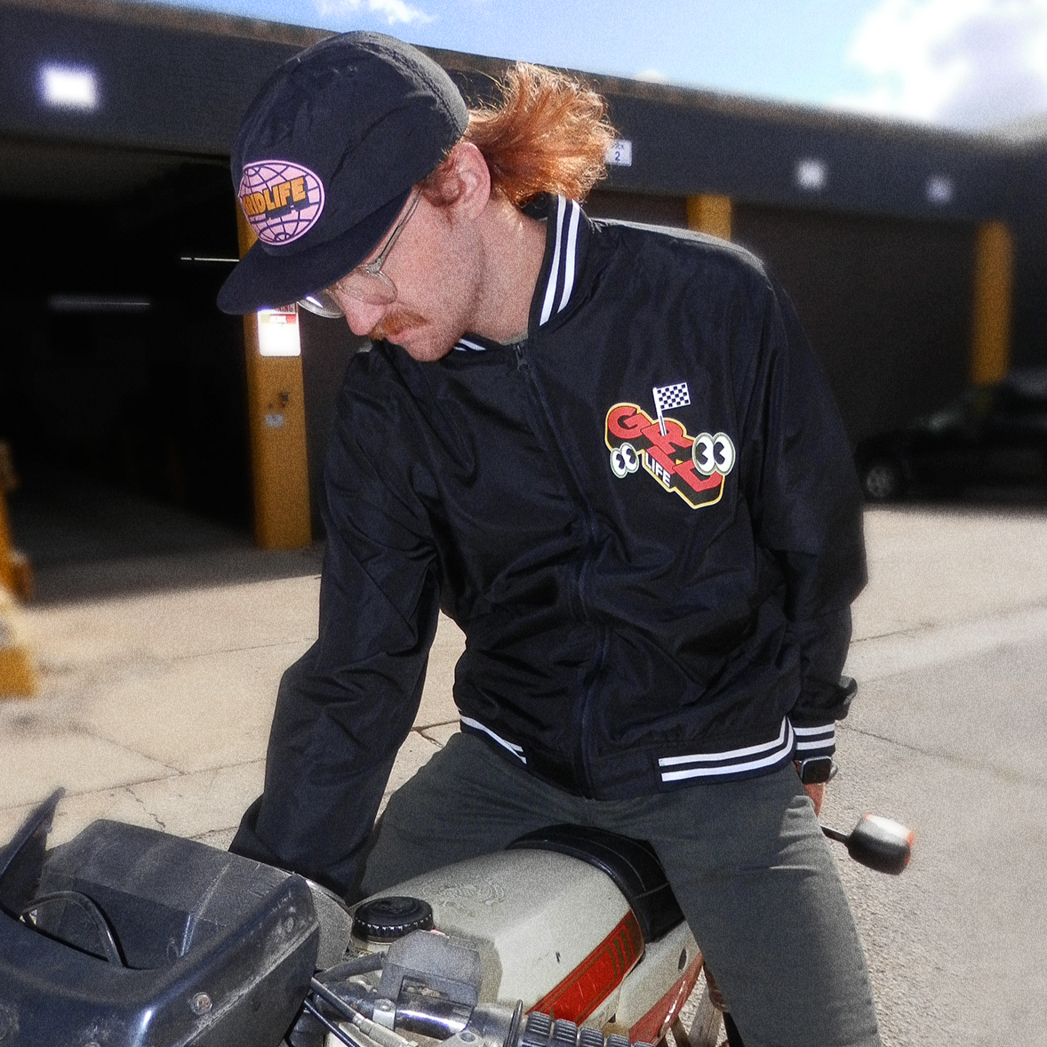 GRIDLIFE lightweight bomber jacket being worn by moped rider outside