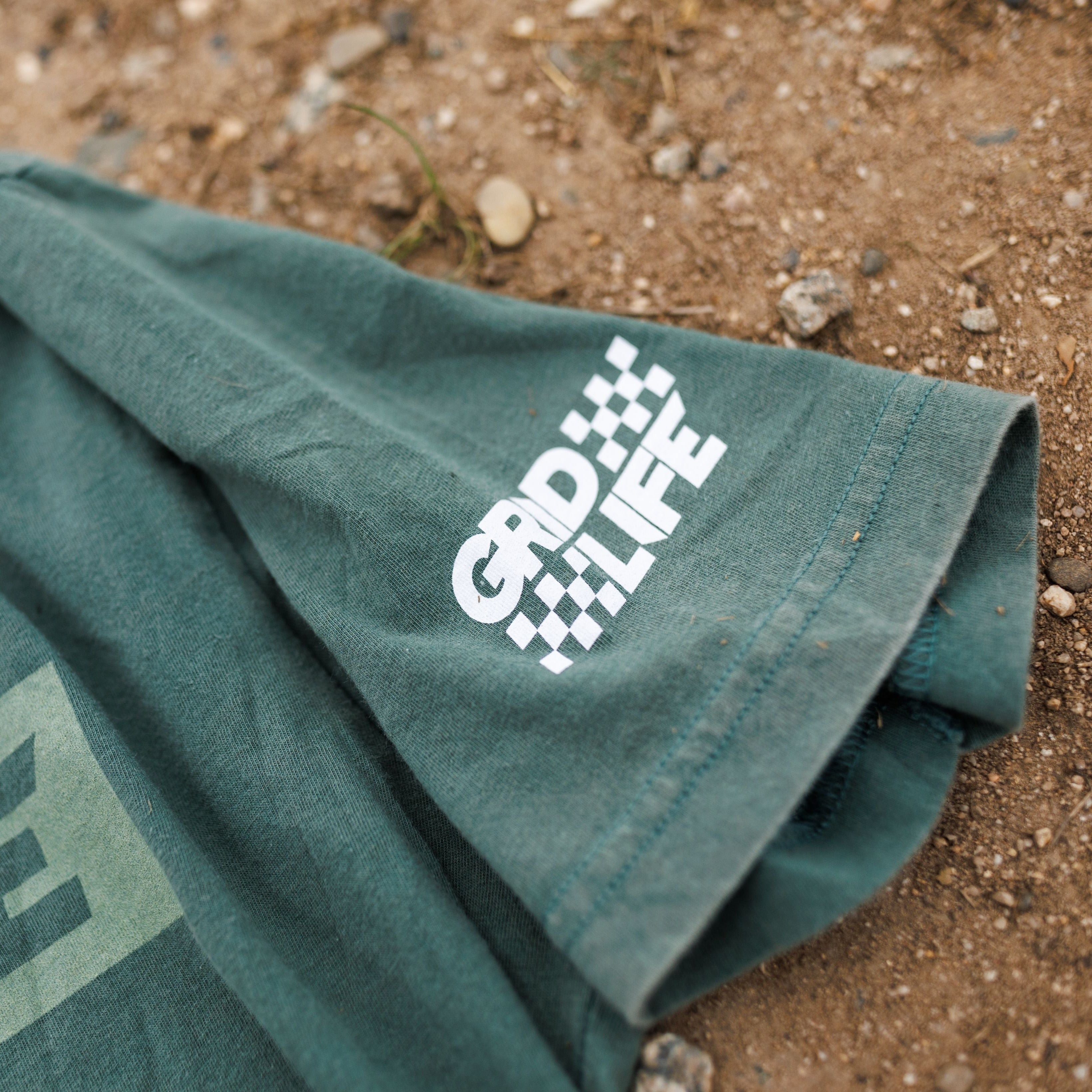 Close up shot of the sleeve logo on the Dark Green GRIDLIFE flag logo shirt