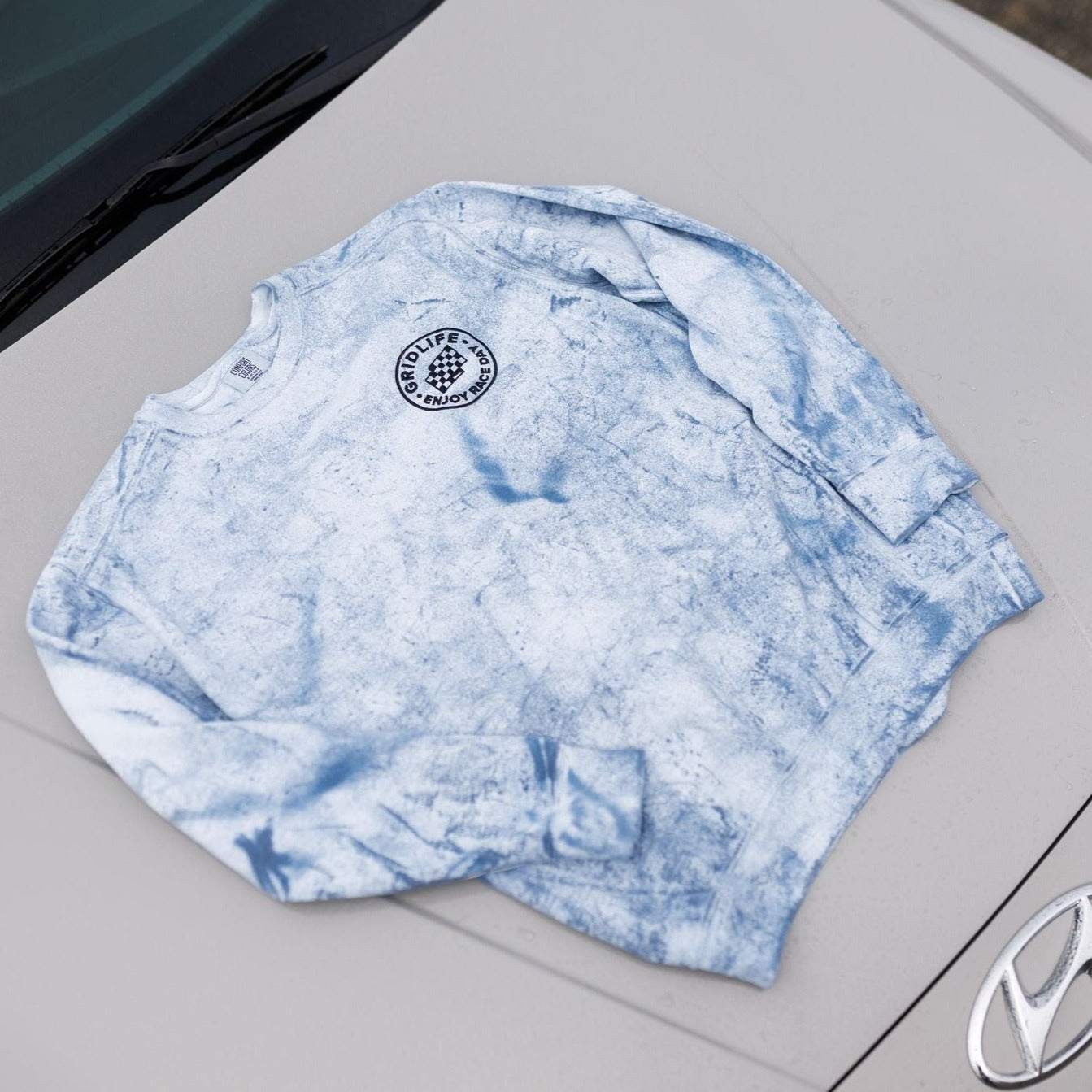 Embroidered GRIDLIFE Enjoy Race Day crewneck on the hood of an Elantra N 